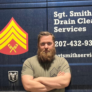 photo of Micah Smith in front of Sgt. Smith's Drain Cleaning truck