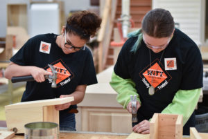 Two young woman building with wood