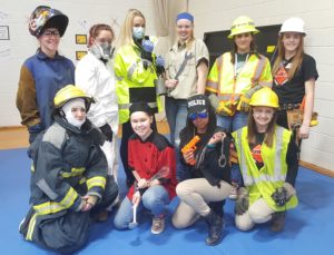 Totally Trades participants dressed up for a fashion show with clothing from their chosen career.