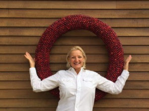 Deena Prestegaard in front of cranberry wreath