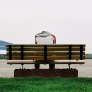 Person sitting on bench near water