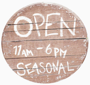 Sign saying open 11 AM - 6 PM seasonal