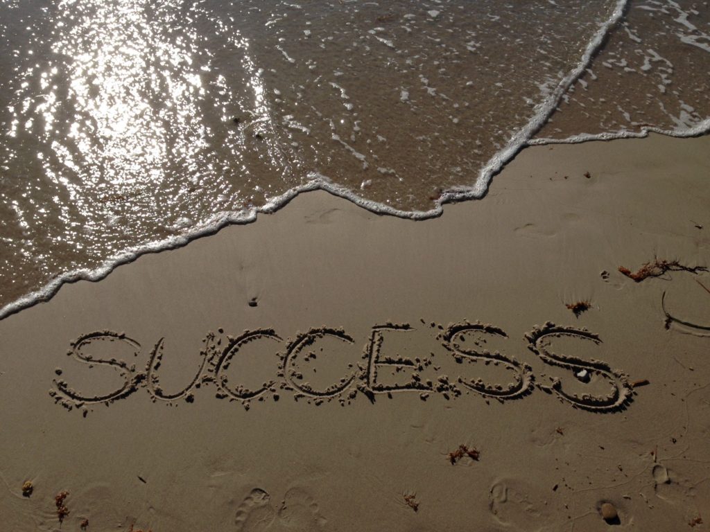 sandy beach with the word success in the sand