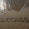 sandy beach with the word success in the sand