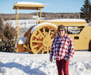 Shiela standing in front of a large tractor