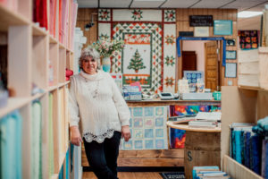 Susan standing in her colorful quilting shop
