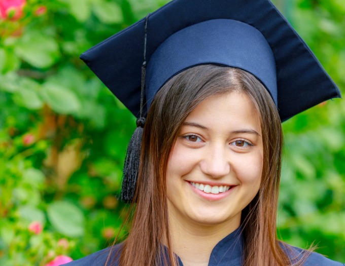 photo of smiling college grad wearing blue mortar board