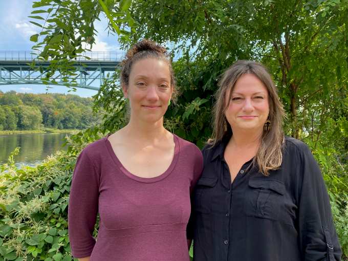 photo of Martha Leonard (left) and Gina Platt (right) in front of trees by the Kennebec River