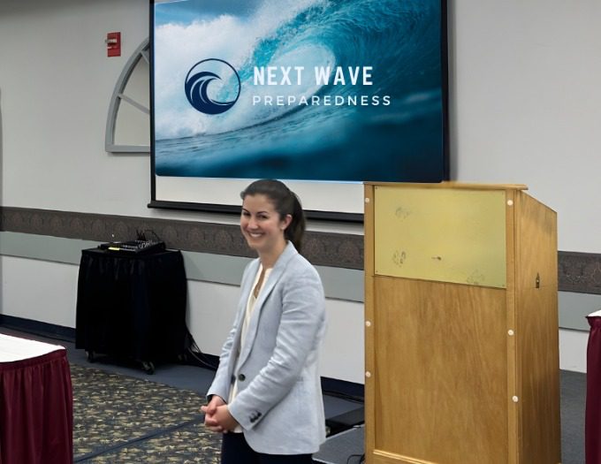 Emily Kaster of Next Wave Preparedness stands at the front of a room giving a presentation