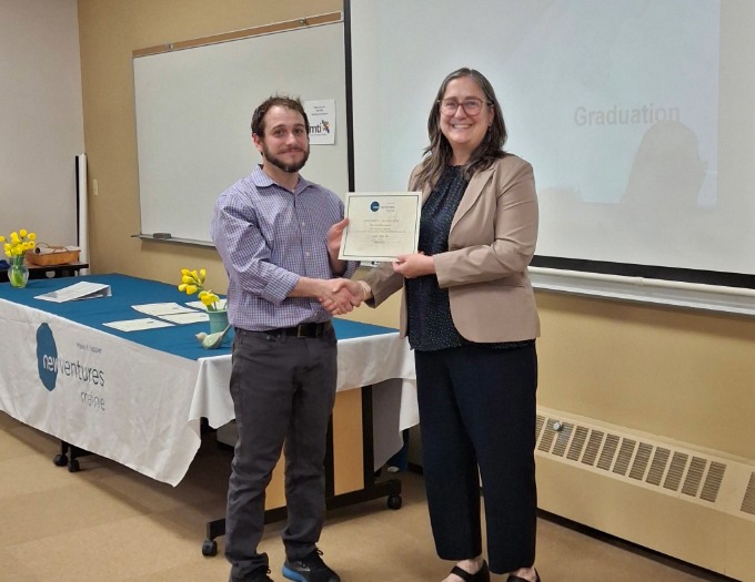 Zach receives a class certificate from Alicia